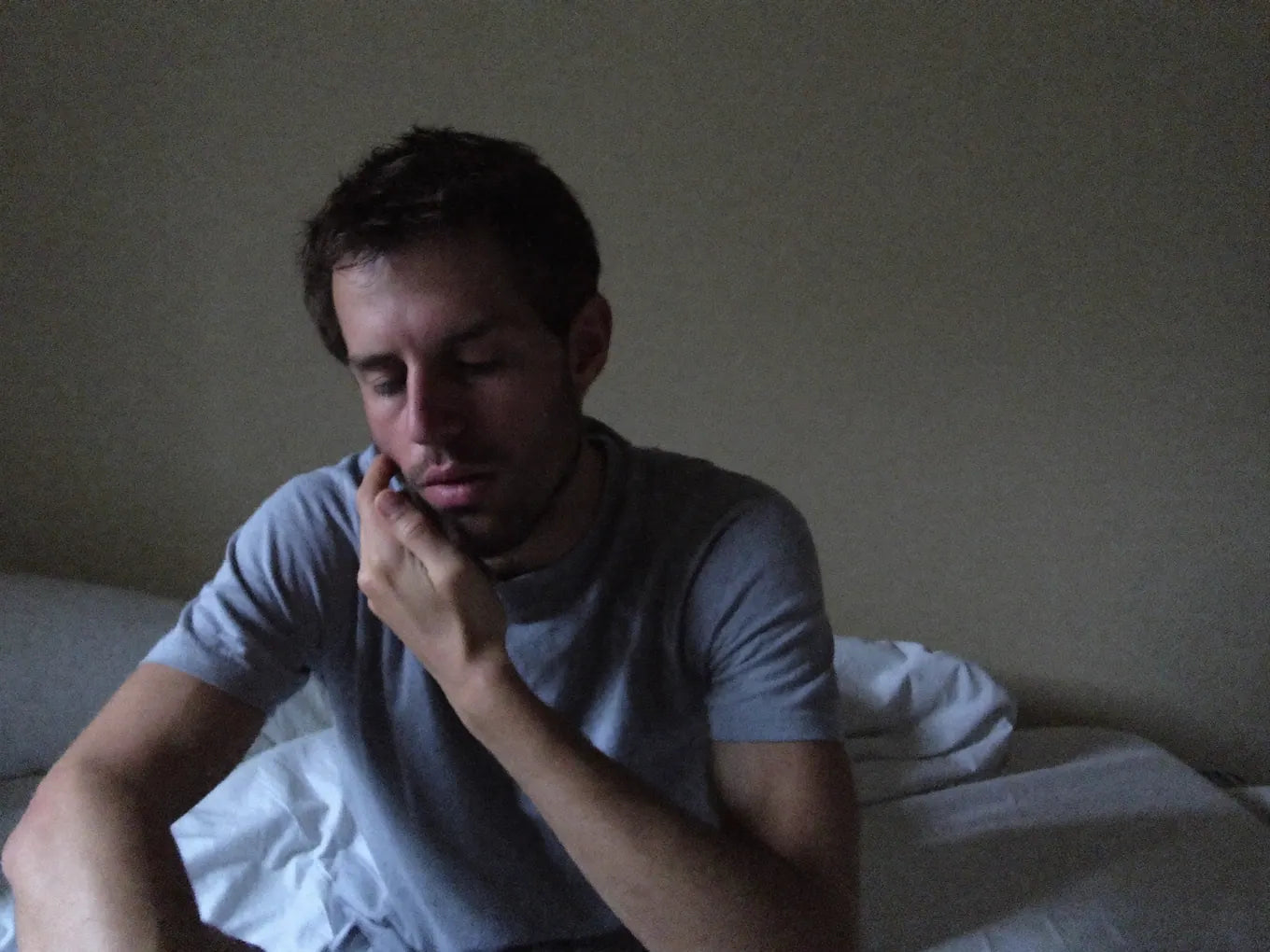 UGC PHONE PHOTO — exhausted 36yo man on edge of bed, morning light, rubbing face