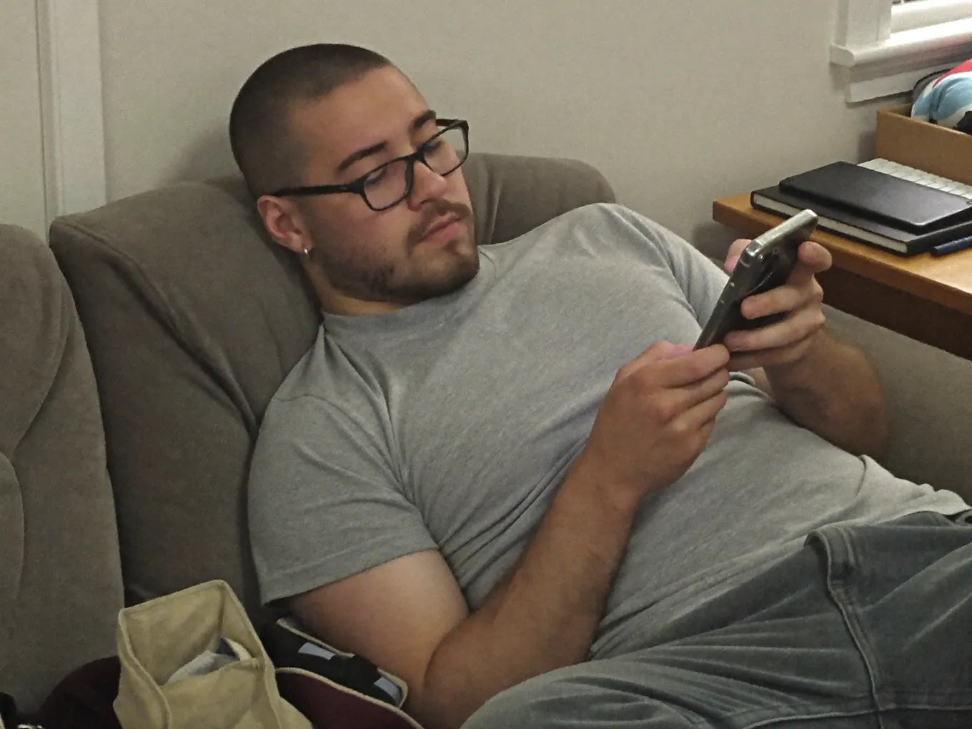 Man slumped on the couch endlessly scrolling